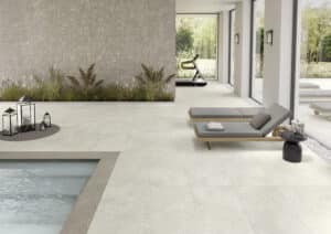 C. Bergmann zeigt ein Indoorpool mit Fitnessraum und beige marmorierten rechteckigen Bodenfliesen von Keope Arke.