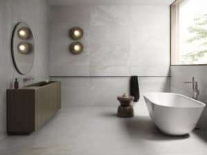 C. Bergmann zeigt ein elegantes Badezimmer mit großflächigen grau marmorierten Wand- und Bodenfliesen und stäbchenförmigen Wandfliesen von Villeroy & Boch.