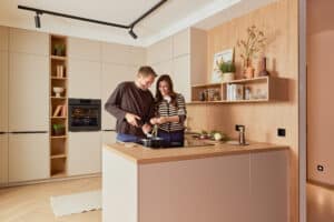 DANKÜCHEN zeigt eine Küche in warmen Farbtönen mit einem Materialmix aus hellem Holz und Fronten in einem Beige-Kaschmirfarbton in gemütlicher Wohnatmosphäre.