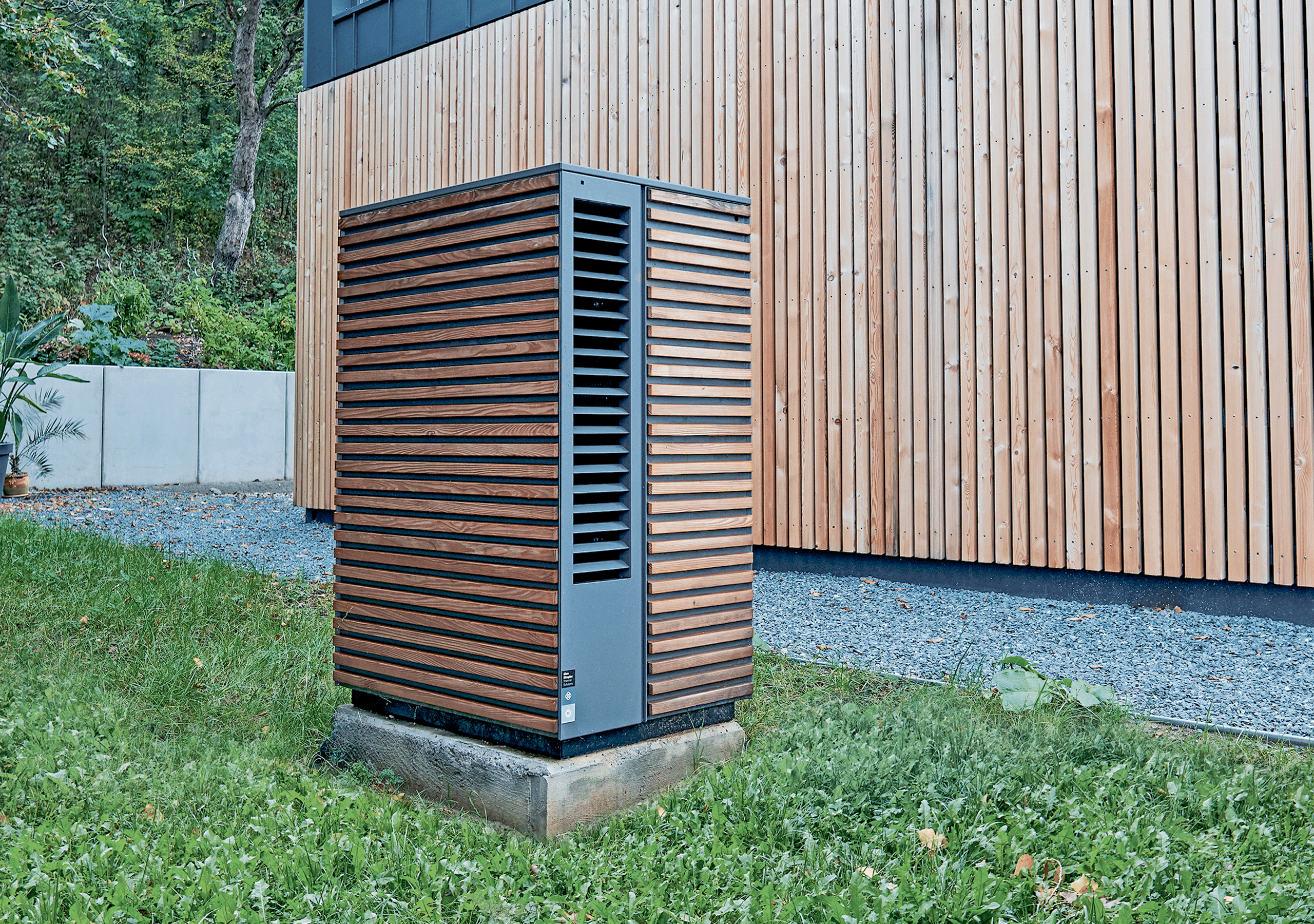 Dimplex zeigt eine Wärmepumpe mit Holzverkleidung im Außenbereich eines modernen Hauses im gleichen Design.