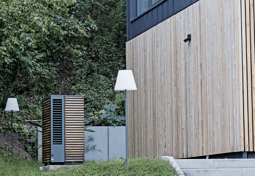 Dimplex zeigt eine Wärmepumpe mit Holzverkleidung im Außenbereich eines modernen Hauses im gleichen Design.