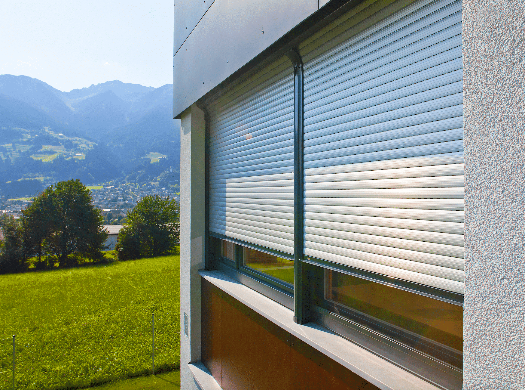 Hausfassade mit Blick in die Berge und Rolläden von DolenzGollner Sonnenschutztechnik Ing. Wagner GmbH.