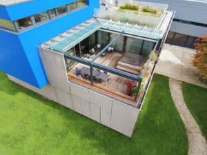 Dachterrasse, Loggia oder Wintergarten mit verglastem Dachvorsprung und geöffnetem PVC-Dach von DolenzGollner.