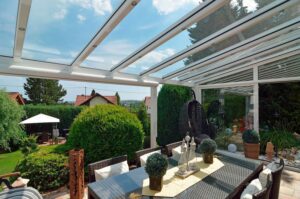 Wintergarten mit weissem Alu-Rahmen, Pultdach, Glasschiebetüren und Rollo von DolenzGollner.