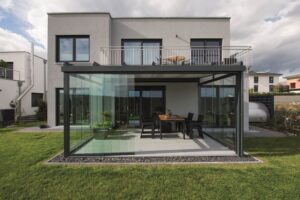 Einfamilienhaus mit angebautem Wintergarten in schwarzem Alu-Rahmen und Glasschiebe-Elementen von DolenzGollner.