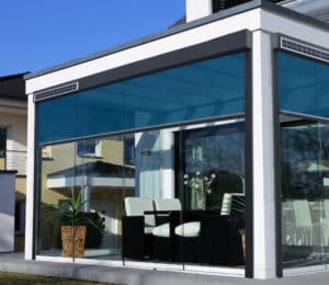 Wintergarten mit schwarzweissem Alu-Rahmen, Glasdach, Glasschiebetüren und einem solarbetriebenem Außenrollo von DolenzGollner.