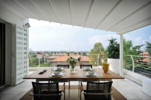 Dachterrasse mit schrägverlaufendem elektrischen Sonnendach zur Beschattung in Weiss von DolenzGollner.