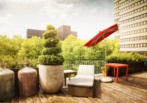Dachterrasse eines Wohnhauses mit geneigtem, freistehenden Alu-Sonnenschirm in Rot von DolenzGollner.