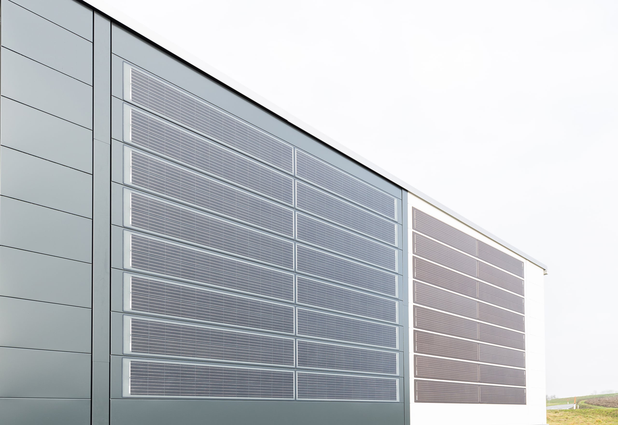 DOMICO zeigt die durchdringungsfreie Planum®Solar-Fassade mit Planum®Solar Glasoberfläche in Grau und Weiß.