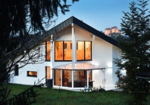 Einfamilienhaus mit Kombinationsdach und großzügiger Terrasse mit Glasüberdachung und Säulen von ERLER Haus.