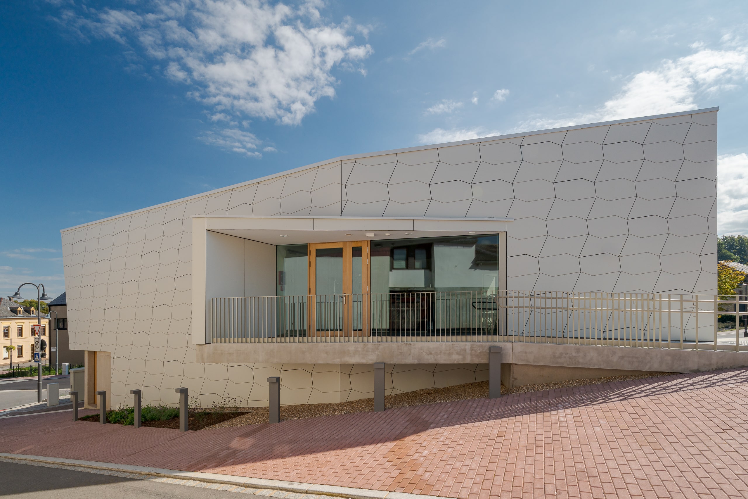 ETVIR zeigt den Seiteneingang mit Aufgang des Referenzprojekts Formsociety Greiveldange mit moderner Fassade.