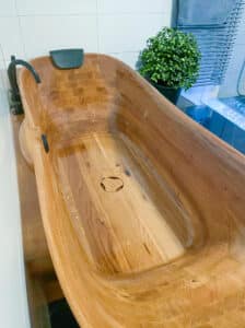 Massivholzbadewanne Relax Comfort von FESTWOOD mit Kopfstütze und schwarzer 4-Loch-Armatur.