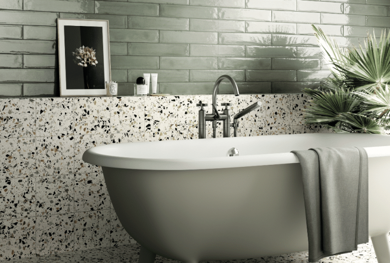 Fliesendorf zeigt ein Badezimmer in mint-grün, freistehender Badewanne und Fliesen im Stracciatella-Look an der Wand.