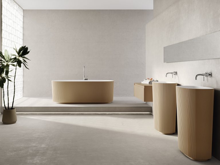 Fliesendorf zeigt elegantes Badezimmer mit freistehendem, hellbraunen Waschbecken und Badewanne mit gerillter Oberfläche.