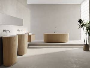 Fliesendorf zeigt elegantes Badezimmer mit freistehendem, hellbraunen Waschbecken und Badewanne mit gerillter Oberfläche.