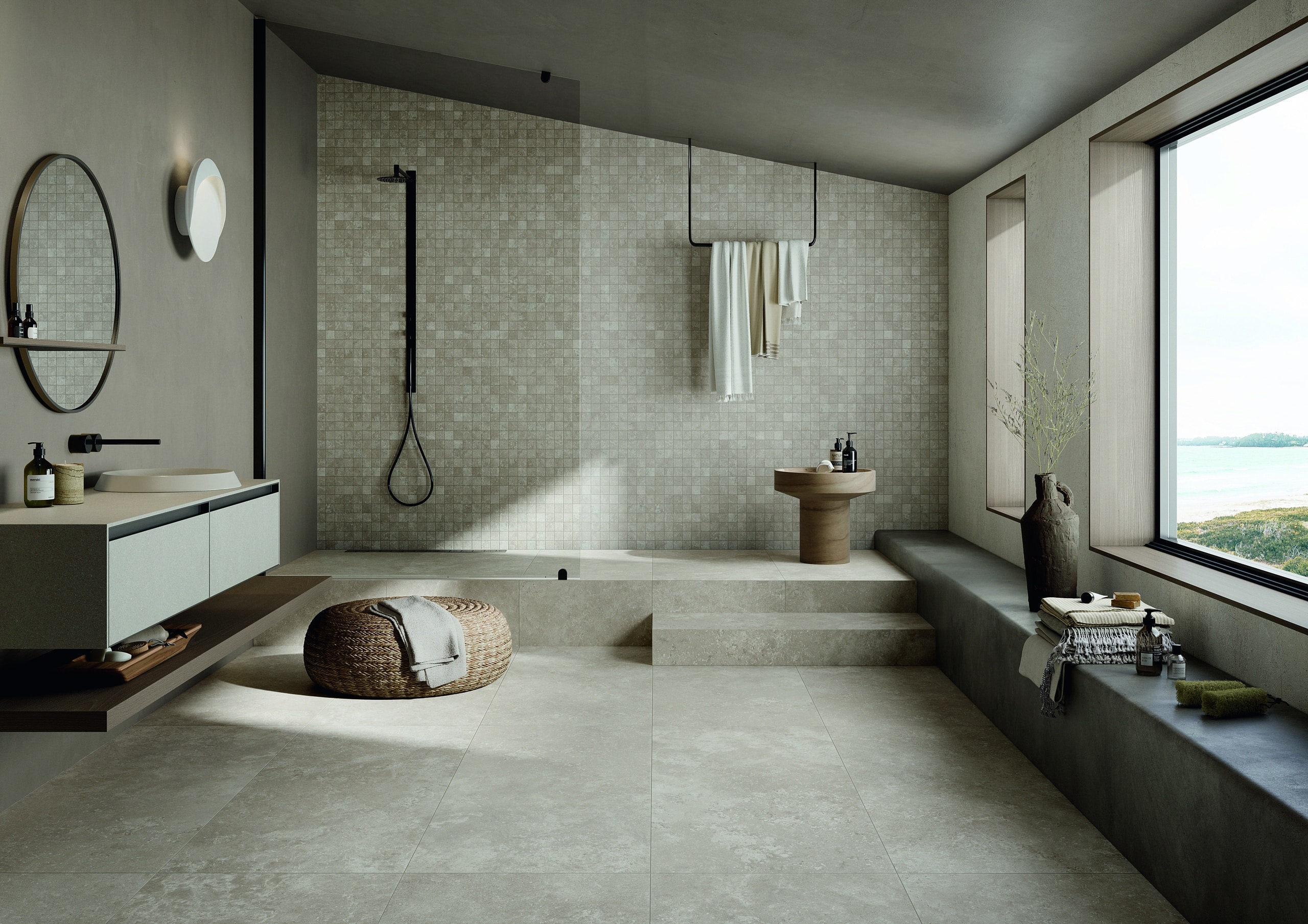 Fliesendorf zeigt ein Badezimmer mit Dachschräge, Bodenfliesen in grau-beige-weisser Steinoptik, einem Doppelwaschtisch und einen erhöhten Aufgang zur Duschnische mit einer Rückwand aus beigen Mosaikfliesen.