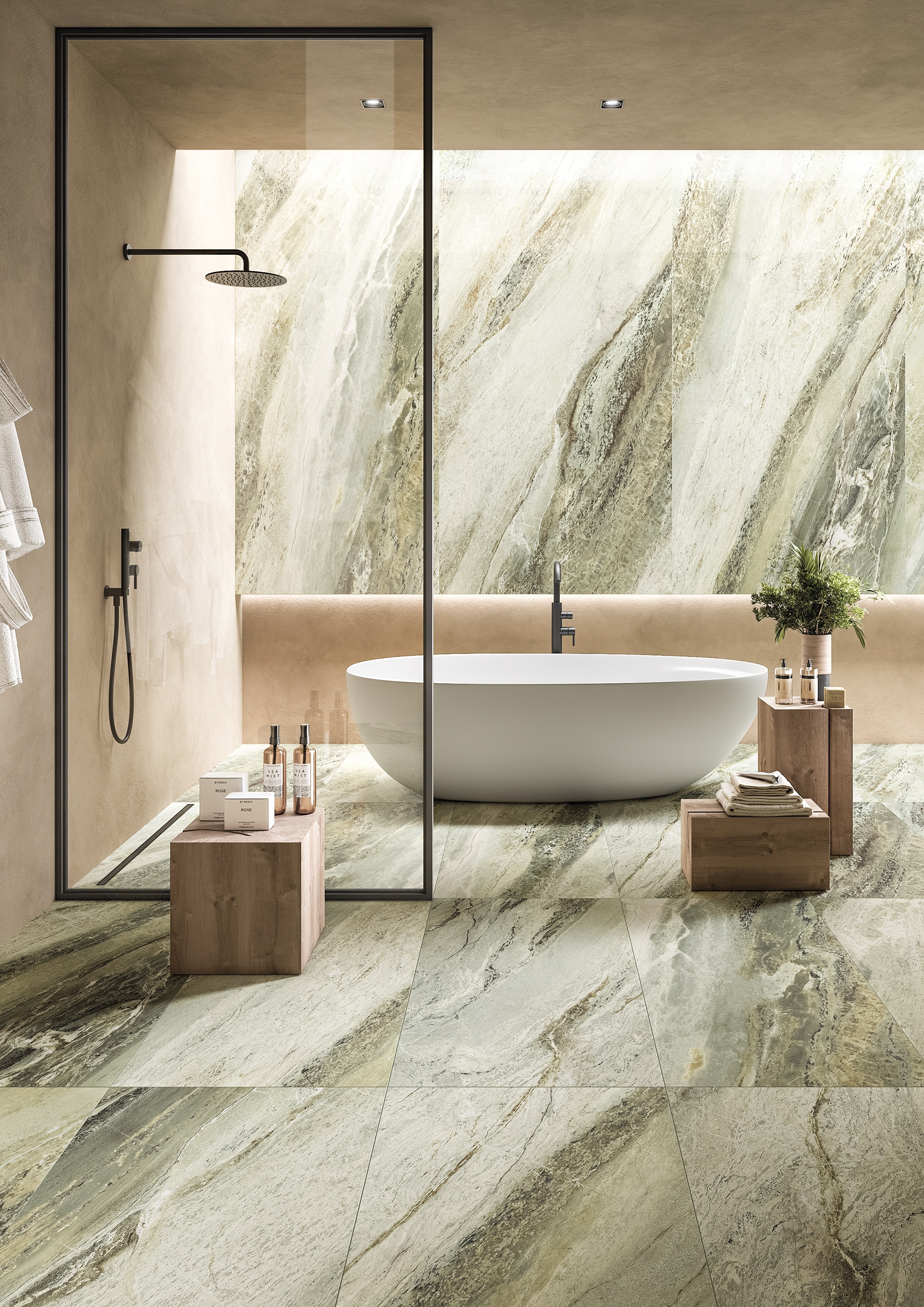 Fliesendorf zeigt ein Badezimmer mit freistehender ovalen Wanne, Duschnische mit Regenduschkopf und Glaswand und Wand- und Bodenfliesen in grün-grauer Marmoroptik.