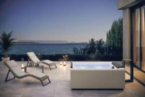 Außenbereich mit großzügigen Terrassenfliesen und stilvoller Lounge mit Meerblick und einem Whirlpool der Divina-Reihe von Fliesendorf.