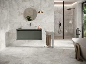 Modernes Badezimmer mit großformatigen grau-weißen Natursteinfliesen an Wand und Boden, aus der Gravina-Reihe von Fliesendorf.