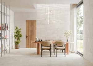 Essbereich mit großformatigen hellen Steinfliesen an Wand und Boden aus der Portland-Rock-Reihe von Fliesendorf, kombiniert mit warmen Holzelementen, natürlichen Farbtönen und modernen Designmöbeln.