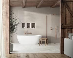 Badezimmer mit großformatigen hellen Fliesen an Wand und Boden aus der Silhouet-Reihe von Fliesendorf, kombiniert mit einer freistehenden Badewanne, gebürsteten Kupferarmaturen, einer rustikalen dunklen Holzdecke und dazu passender "Stalltüre" für einen harmonischen Look.