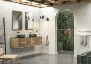 Badezimmer mit waldgrünen Mosaikfliesen in der Dusche und als Badewannenverkleidung, kombiniert mit Kupferarmaturen, einem Holzwaschtisch mit zwei waldgrünen Waschschüsseln und einer Holzdeckenverkleidung aus der Silhouet-Reihe von Fliesendorf.