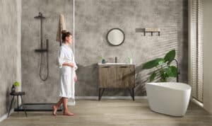 Gerflor präsentiert den Wandbelag Mural Revela in Steinoptik in einem großen Badezimmer mit Dusche und freistehender Badewanne.