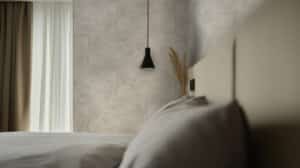 Gerflor präsentiert den grau melierten Wandbelag Mural Revela in einem Schlafzimmer.