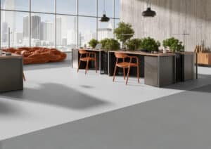 Gerflor präsentiert einen exklusiven hellen Büroraum mit mehreren Arbeitsplätzen und einem mit Lino beschichteten Boden in einem Grauton.