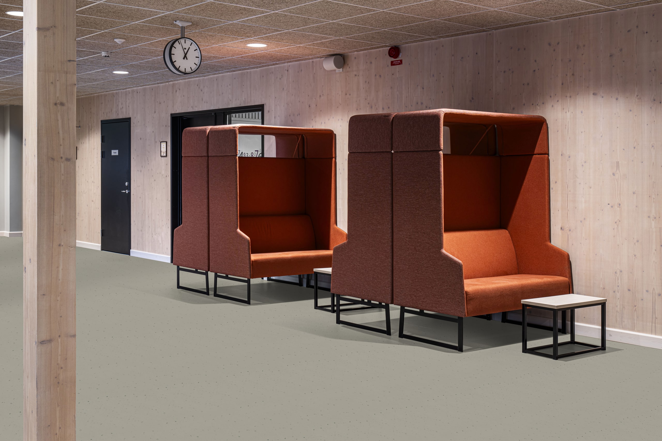 Gerflor zeigt einen Gang mit Sitzgelegenheiten in einem öffentlichen Gebäude mit dem grau gesprenkeltem Bodenbelag Linoleum Lino Art Moon Rock.