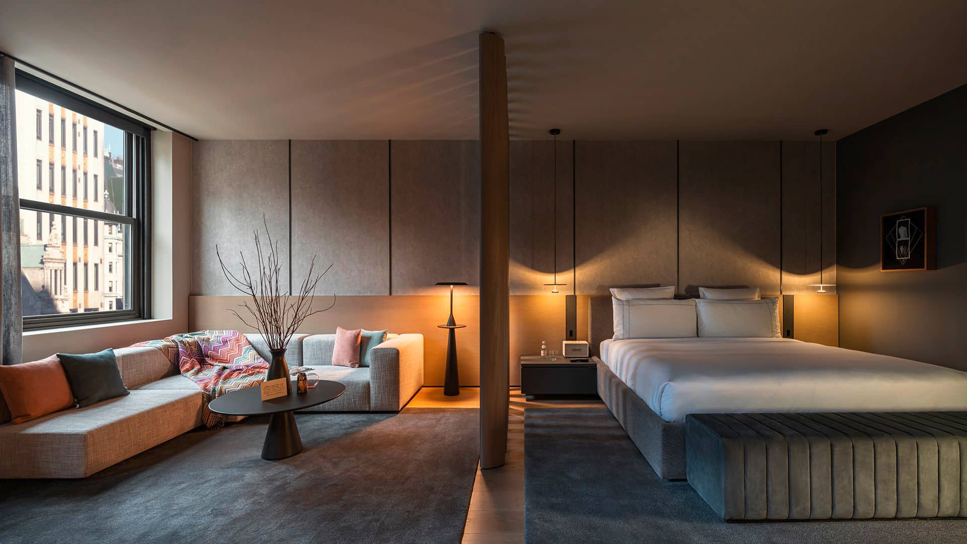 Gessi zeigt ein Zimmer im CORE: New York mit großem Doppelbett und gemütlichem Sofa.