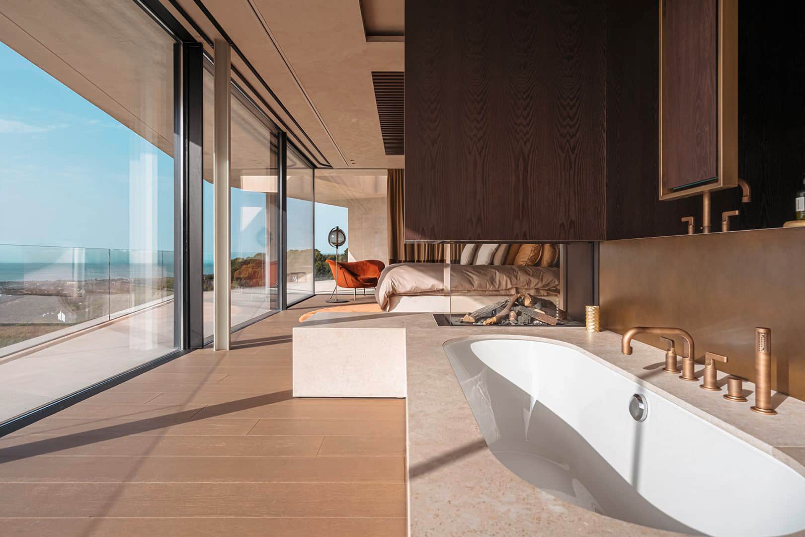 Gessi zeigt das ans Schlafzimmer angeschlossene offene Bad mit Kamin, Wanne und Armaturen aus der Serie Inciso.