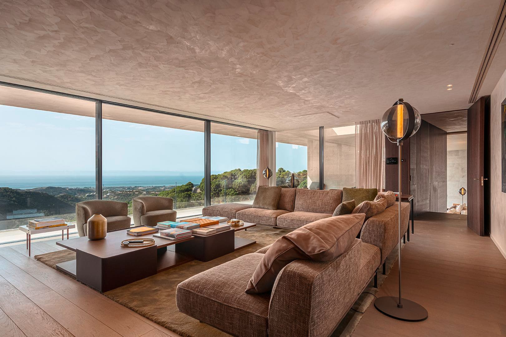 Gessi zeigt den großzügigen Wohnraum in der Casa Cuiabá mit großer Wohnlandschaft und atemberaubendem Ausblick.