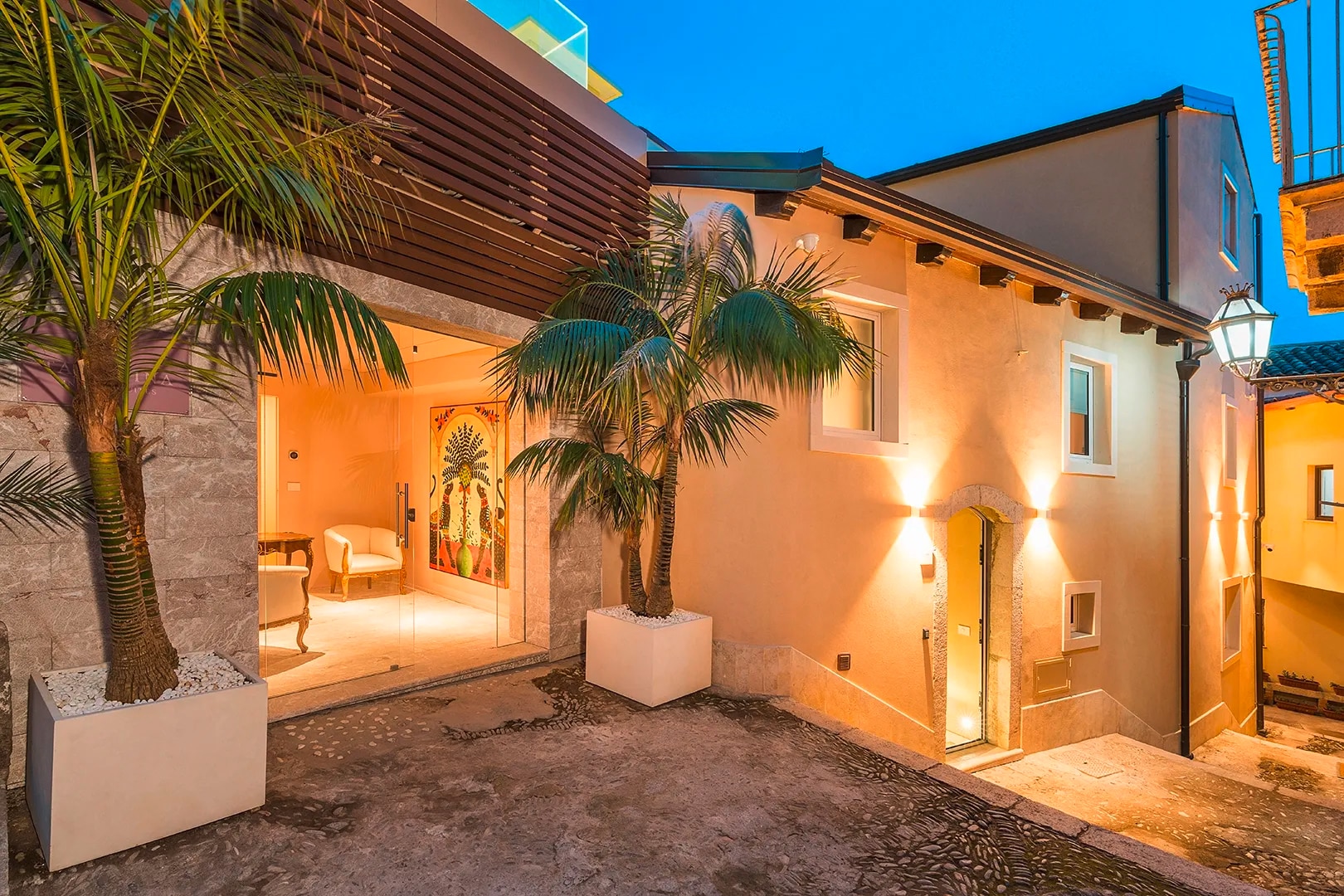 Gessi zeigt den Zugang zu den Taormina Infinity Suites in stimmungsvollen Abendstunden.