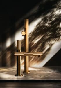 GESSI präsentiert eine elegante Armatur in goldener Farbe mit drehbaren Reglern.