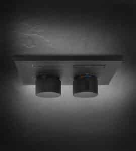 GESSI zeigt ein in der Duschwand integriertes Duschradio mit zwei Drehreglern in schwarz.