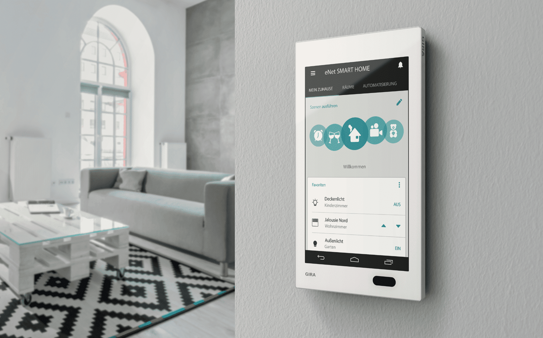 Gira zeigt eine weisse Smart Home Steuerung, mit großem Display, an der Wand zu einem Wohnzimmer mit grauer Couch, einem Palettentisch und einem Rundbogenfenster.
