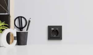 Eine Schuko- und USB-(A + C)-Steckdosenkombination in Schwarz aus dem modularen Programm von Gira.