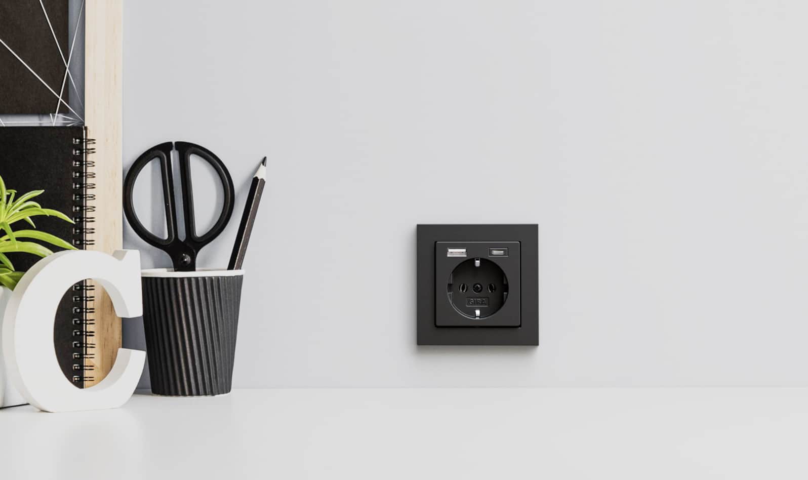 Eine Schuko- und USB-(A + C)-Steckdosenkombination in Schwarz aus dem modularen Programm von Gira.