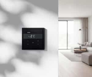 Ein Gira Temperaturregler F300 RKS HLK KNX in Schwarz an einer hellen Wand im Wohnzimmer.