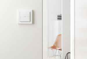 Ein Gira Schalter E2 TS4 55 1F in Weiß mit Licht-/Flur-Beschriftung an einer hellen Wand.