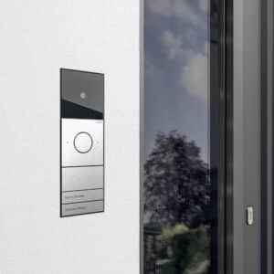 Ein Gira System 106 Gegensprechanlage mit Kamera aus gebürstetem Metall an einer Hauseingangstüre.