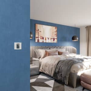 Ein Gira TS4 55 Plus 4F Schalter in Weiß mit schwarzem Anzeigedisplay an einer blauen Wand im Schlafzimmer.