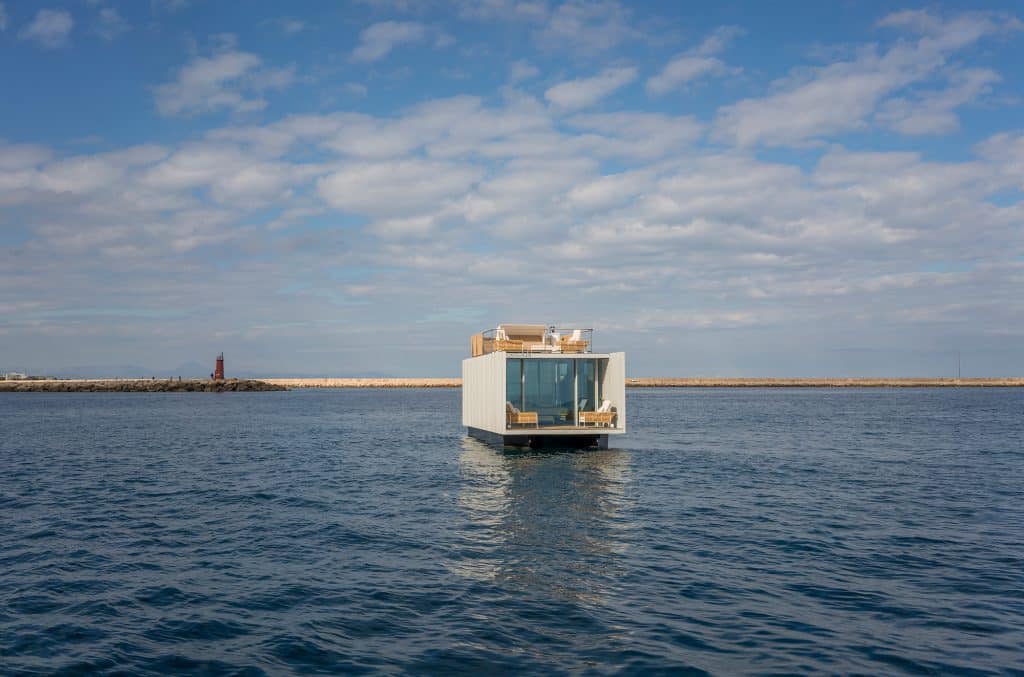 Vorderansicht des schwimmenden Pavillons 'Punta de Mar' mit Outdoorlounge auf Ober- und Unter-Deck und Aussicht aufs offene Meer bereitgestellt von Gira.