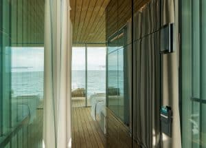 Das Innenleben des schwimmenden Pavillons mit holzdielen, abgetrennter Waschbereich mit verspiegelten Wänden und wandmontiertem G1 Panel und Kartenleser von Gira.