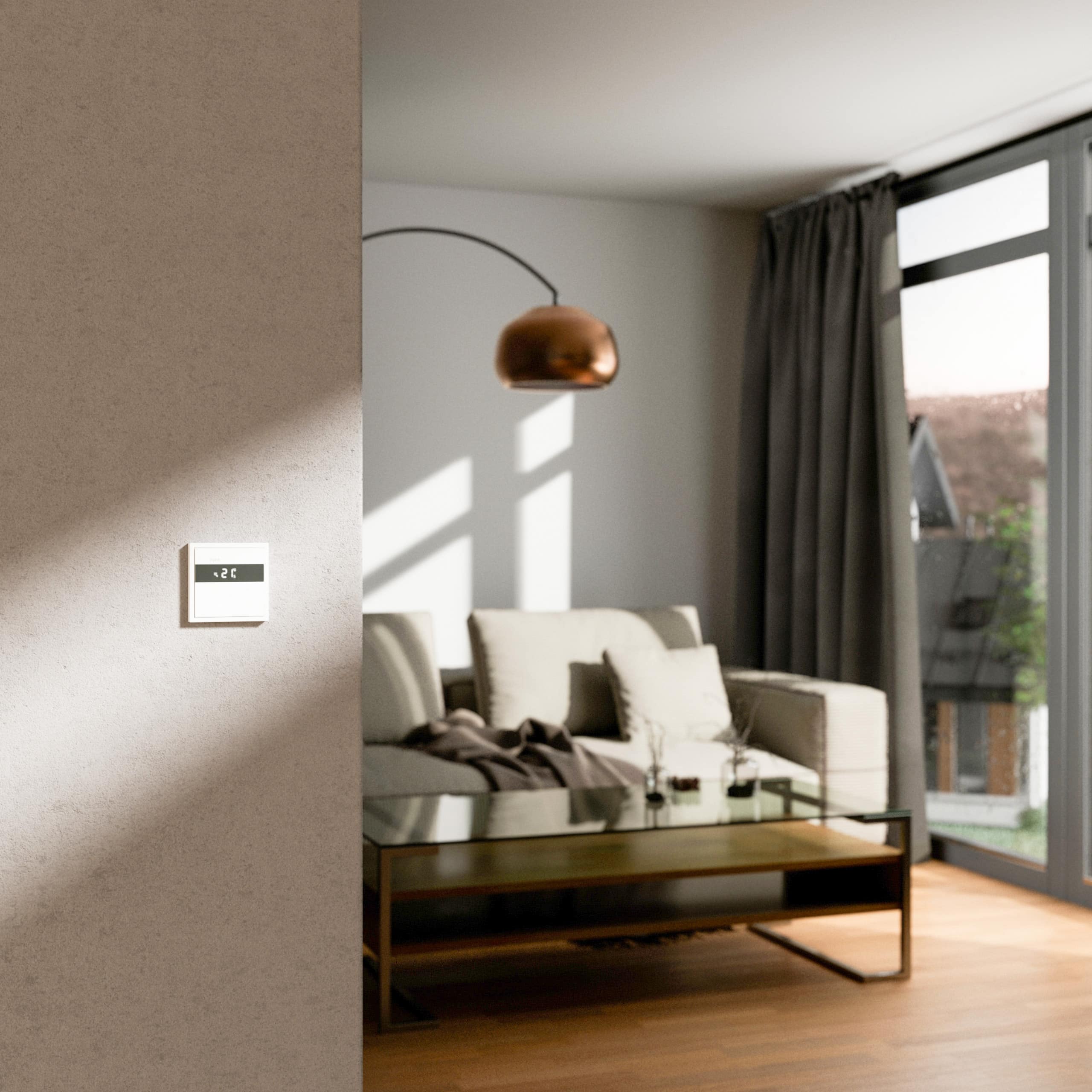Der neue Gira Raumklimasensor für KNX in Weiß mit Temperaturanzeige an einer Wohnzimmerwand mit gedämpftem Licht.