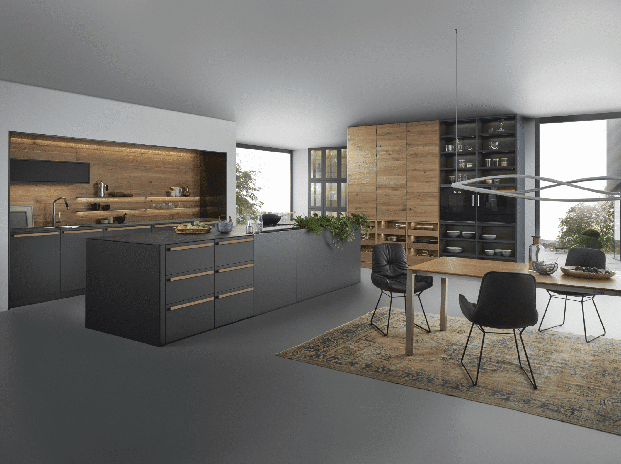 WOHNHAUS Grill & Ronacher zeigt eine moderne Inselküche von LEICHT Küchen mit dunklen, anthrazitfarbenen Holz-Fronten und hohen Schränken mit viel Stauraum.