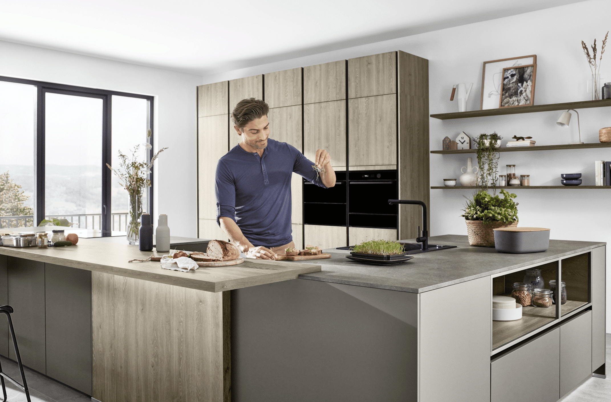 Inselküche mit grauen Fronten, grauer Arbeitsplatte und Holzelementen von Nobilia präsentiert von Grill & Ronacher.