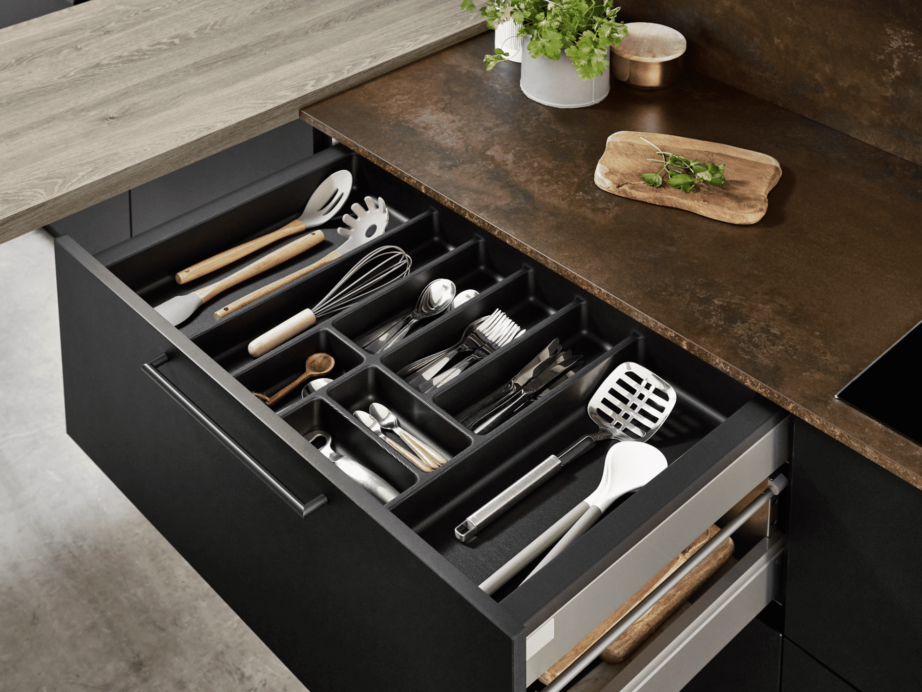 Geöffnete Küchenschublade mit schwarzen Fronten, brauner Arbeitsplatte und Bartischplatte in Holzoptik von Nobilia präsentiert von Grill & Ronacher.