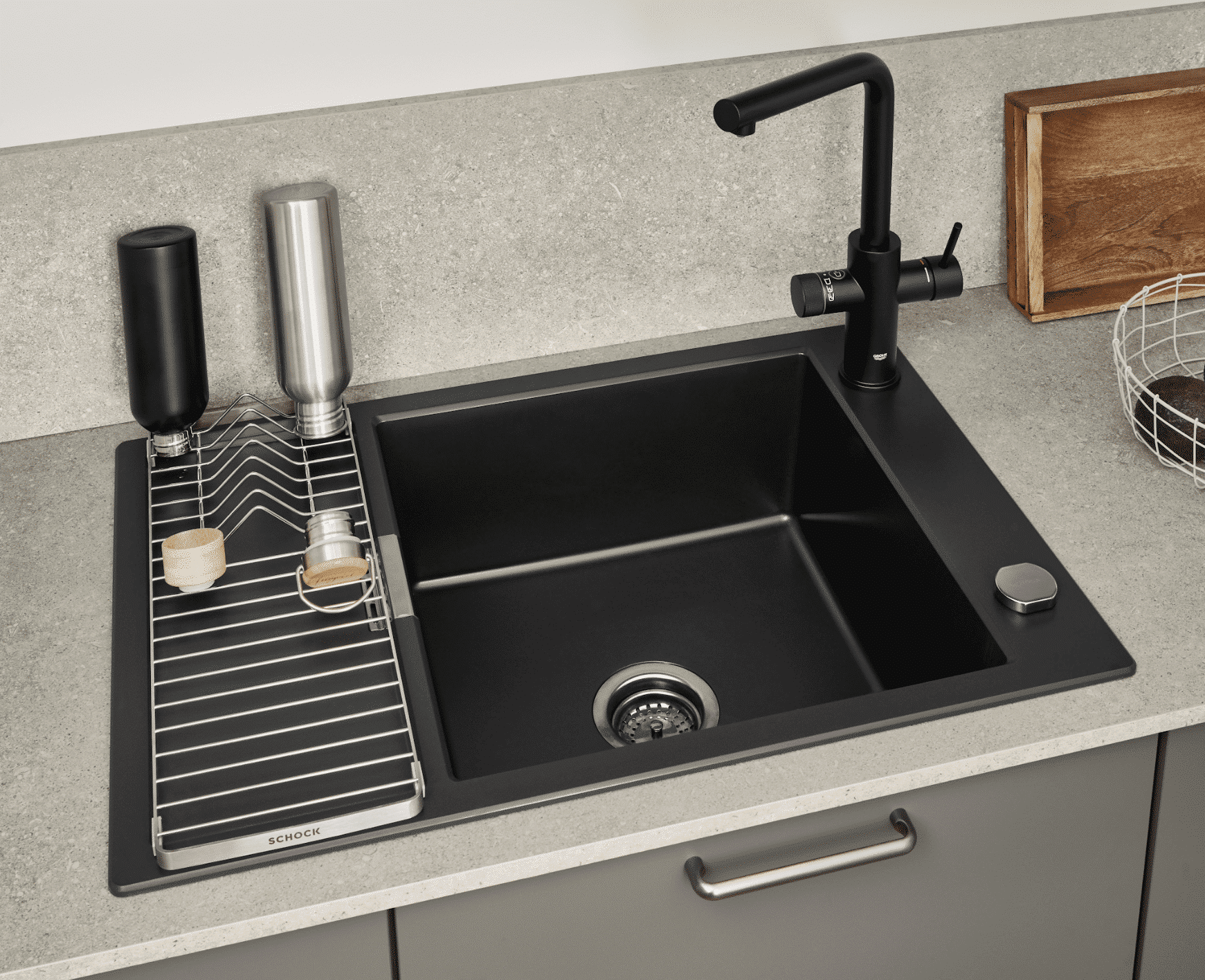 Küche mit grauen Fronten, einer Arbeitsplatte und Rückwand in Steinoptik und einer Mischbatterie und Spüle in Schwarz von Nobilia präsentiert von Grill & Ronacher.